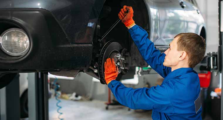man adjusting alignment on car